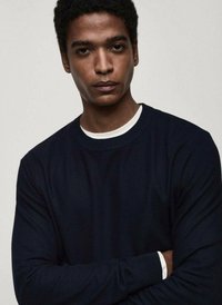 Maglione navy a maniche lunghe con un design a maglia testurizzata. Presenta un colletto e polsini a contrasto bianchi, dettagli aderenti e una forma rilassata.