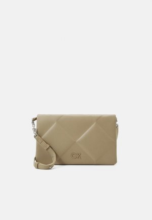 Beżowa pikowana torebka crossbody z regulowanym paskiem, srebrnym łańcuszkiem i wytłoczonym logo "CK" na przedniej klapie.