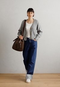 Gray ribbed cardigan with buttons, white T-shirt, high-waisted blue jeans, and white sneakers; carrying a brown handbag.