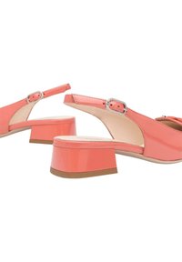 Scarpe slingback in pelle verniciata rosa con chiusura a fibbia, tacco quadrato e superficie liscia. Caratterizzate da un design minimalista.