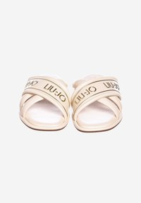 Infradito beige con due cinturini incrociati che presentano il logo dorato "LIU∙JO". Superficie superiore liscia e suola piatta e larga per il comfort.