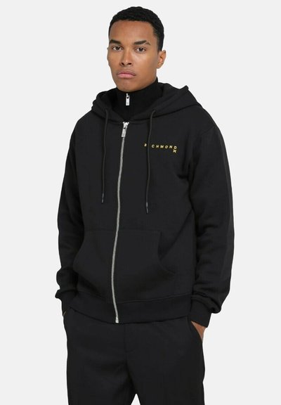 Felpa nera con zip, tasca frontale, coulisse e logo dorato "RICHMOND" nell'area sinistra del petto. Materiale morbido, vestibilità standard.