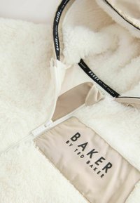 Crème kleurige fleece hoodiejack met een zachte textuur, voorzien van een tan kleurig ritspaneel en een logopatch met de tekst "BAKER by TED BAKER."