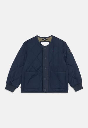 Veste matelassée bleu marine avec boutons-pression, deux poches avant, poignets côtelés et petit logo sur la poitrine et la manche.