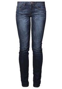 Jean slim bleu foncé avec fermeture à boutons et zip, cinq poches, et légère décoloration sur les cuisses et les genoux.