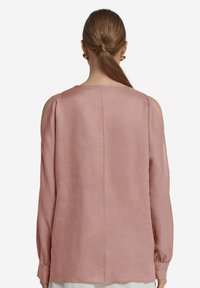 Ljusrosa långärmad blus i linne, med design som har öppna axlar och lätt gatherade ärmslut. Slät textur med minimala detaljer.