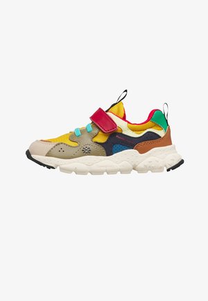 Children’s multicolor sneaker with yellow, red, green, and blue panels, turquoise laces, red velcro strap, and thick white sole with black tread.