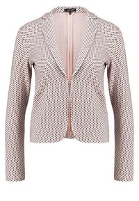Blazer rose clair avec une finition texturée et un motif de petits points noirs. Il possède un col et une fermeture éclair centrale. Manches longues.