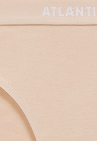 Beżowe bawełniane majtki z elastycznym pasem, na którym widnieje napis "ATLANTIS" w białym kolorze. Gładka tekstura i wyprofilowany kształt.