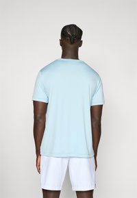 Light blue short-sleeve t-shirt made from smooth fabric, featuring a crew neck and a relaxed fit, paired with white shorts.