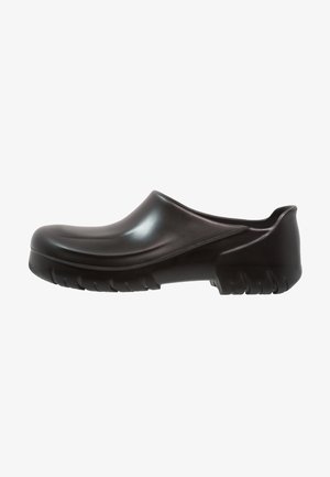 Schwarze Clogs aus glattem Kunststoff mit abgerundeter Spitze und niedrigem Rücken. Die strukturierte Sohle bietet Grip und ist mit erhöhten Rillen für Stabilität ausgestattet.
