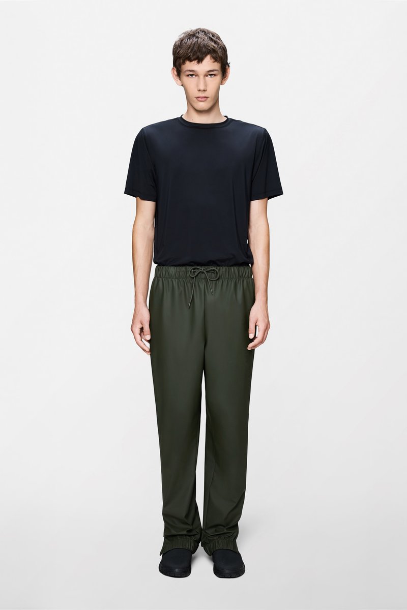 Čierne krátke tričko s krátkym rukávom, skombinované s tmavozelenými nohavicami s elastickým pásom. Hladká látka, voľný strih a nariasené manžety na nohaviciach.