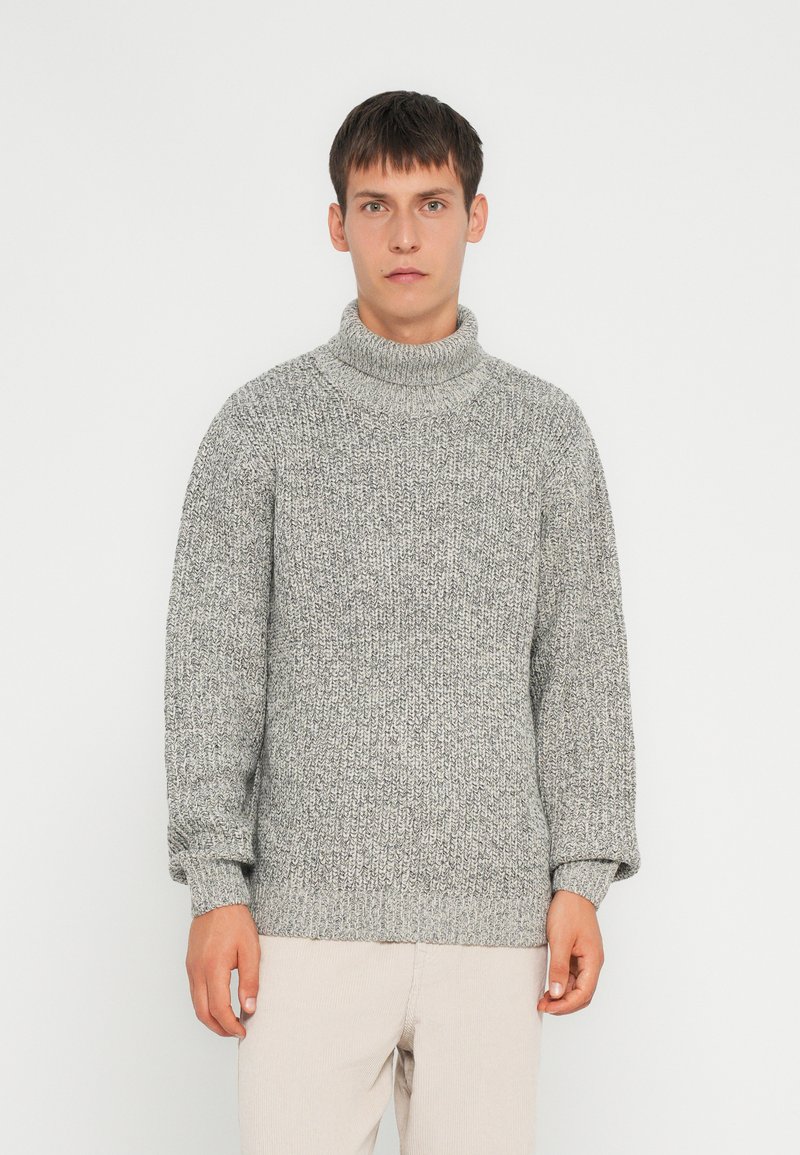 Maglione grigio a collo alto lavorato a maglia con un motivo testurizzato e polsini a coste. La vestibilità è rilassata, con un corpo dritto e spalle leggermente scese.