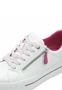 White sneaker with pink accents, textured laces, and a side zipper. Features a thick white sole with a contrasting red trim.