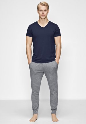 Marine V-hals T-shirt kombineret med lysegrå slim-fit sweatpants. Begge beklædningsgenstande har blødt stof, og bukserne har elastiske manchetter.