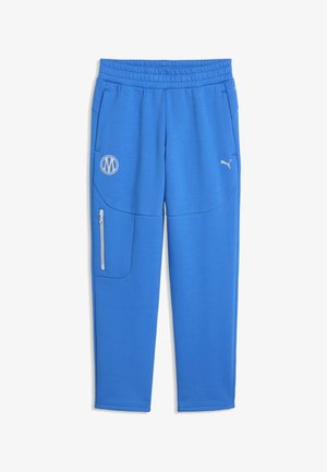 Blaue Sporthose mit elastischem Bund, Reißverschlusstasche am linken Bein und weißem Puma- sowie rundem Logo auf den oberen Oberschenkeln.