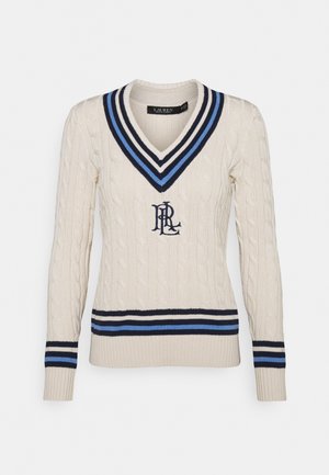 Pull en maille cablée couleur crème avec un décolleté en V profond. Présente des rayures bleu marine et bleu ciel au niveau de l'encolure et de l'ourlet, ainsi qu'un logo en bleu foncé.
