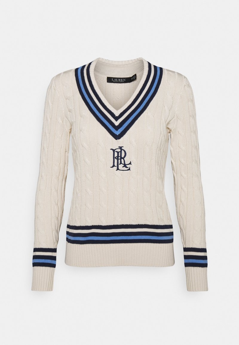 Pull en maille cablée couleur crème avec un décolleté en V profond. Présente des rayures bleu marine et bleu ciel au niveau de l'encolure et de l'ourlet, ainsi qu'un logo en bleu foncé.