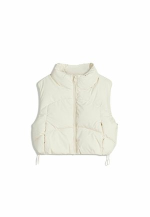 Ljusbeige pufferväst med hög krage, framdragkedja och två stora vadderade sektioner, med justerbara dragsnören i nederkant.