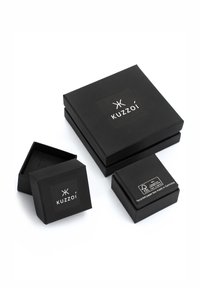 Mustad taaskasutatud paberist kinkekarbid erinevates suurustes, millel on "Kuzzoï" logo, matt viimistlus ja sisekambritega ruudukujulised karbid.