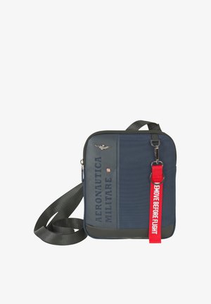 Borsa a tracolla blu navy con tracolla nera, scritta "Aeronautica Militare", emblema militare e targhetta rossa "Remove Before Flight" attaccata.