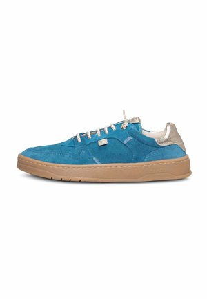 Zapatilla azul de ante con suela beige y detalle metálico beige en el talón, con cordones blancos y etiqueta con logo lateral sobre fondo blanco.