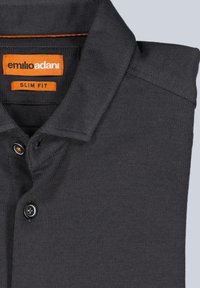 Dunkelgraues Poloshirt mit schlanker Passform. Verfügt über einen strukturierten Stoff, eine Knopfleiste mit drei Knöpfen und einen orangefarbenen Aufnäher mit Markenname und Größe.