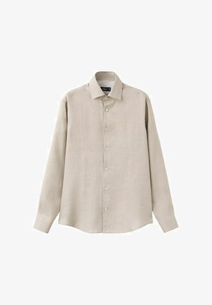 Chemise beige à manches longues avec col pointu, boutons visibles sur le devant et poignets boutonnés, sur fond blanc.