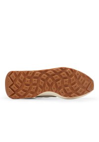 Semelle de chaussure avec un design texturé mettant en avant un motif en losange. Matériau en caoutchouc, dans des teintes de brun et de crème. Marque sur le côté.