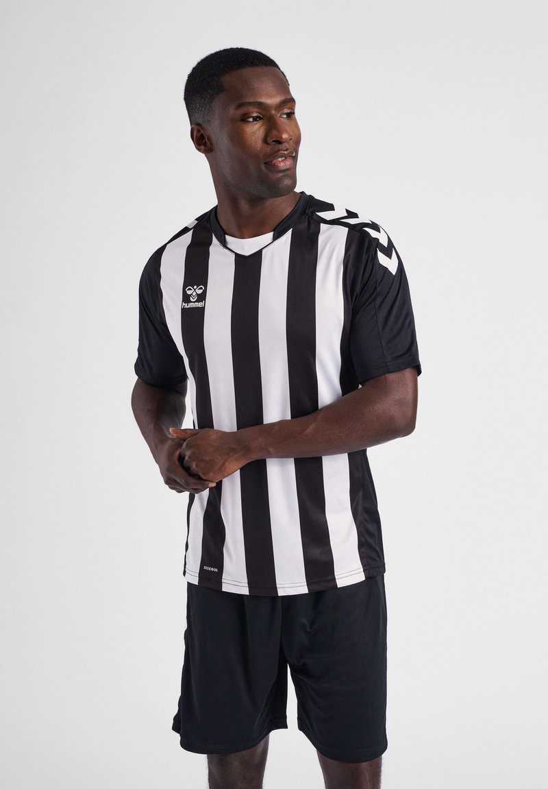 Sort-hvidstribet trøje med korte ærmer, featuring en V-hals og sporty tekstur. Båret med sorte shorts og et humel-logo på brystet.