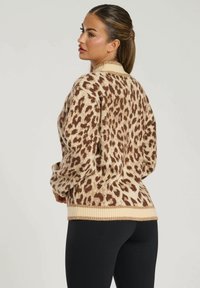Maglione a stampa leopardata in beige e marrone, con colletto e orlo a costine, realizzato in tessuto morbido con un design a vestibilità rilassata.