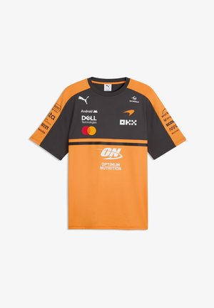 Kurzärmeliges Sporttrikot in Orange und Dunkelgrau mit mehreren Sponsorlogos, darunter Puma, Dell, Mastercard und Optimum Nutrition.