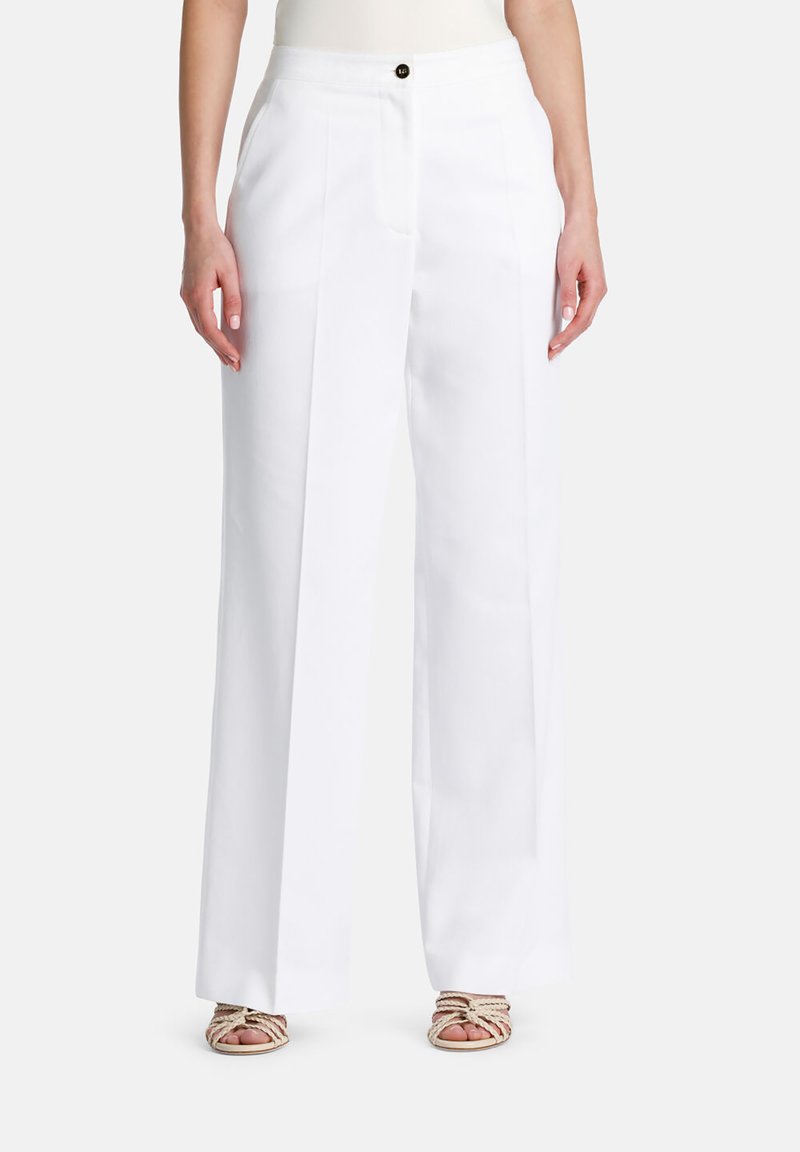 Witte wijde broek van een lichte stof, met geplooide voormouwen en een enkele zwarte knop op de taille.