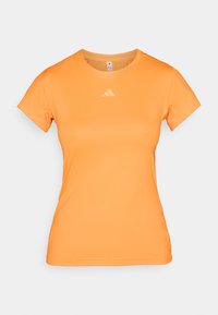 Tricou sport portocaliu cu mâneci scurte, cu textură canelată și un logo subtil pe partea superioară a pieptului. Fabricat din material ușor și elastic.