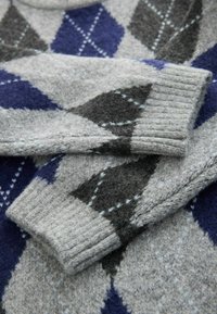 Grau Wollpullover mit einem Argyle-Muster in Dunkelgrau, Marineblau und Hellblau. Ribbed Bündchen und eine weiche Textur sind auffällige Details.