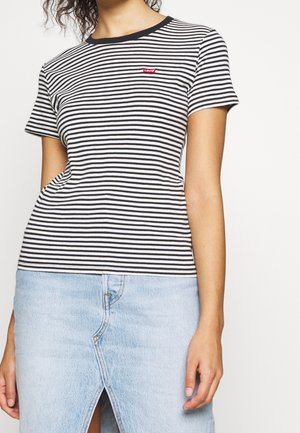 Bawełniana koszulka w czarno-białe paski z okrągłym dekoltem, krótkimi rękawami i małym czerwonym logo Levi's na piersi. W połączeniu z jasną spódnicą jeansową.