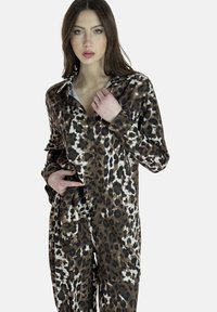 Set di pigiami a stampa leopardata realizzato in tessuto morbido; presenta maniche lunghe, chiusura con bottoni e una combinazione di colori marrone, nero e bianco.