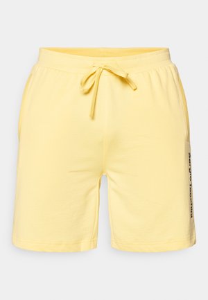 Lys gule shorts laget av myk bomull, med elastisk midje med snor og sidelommer. Utmerket merking på siden.