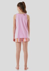 Haut sans manches rose associé à un short à rayures multicolores comprenant du orange, du blanc et du rose. Design décontracté, tissu doux, longueur sous la taille.