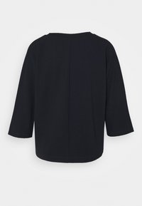 Maglietta nera con texture, maniche a tre quarti e scollatura rotonda. Presenta un taglio semplice e dritto e un design minimalista.