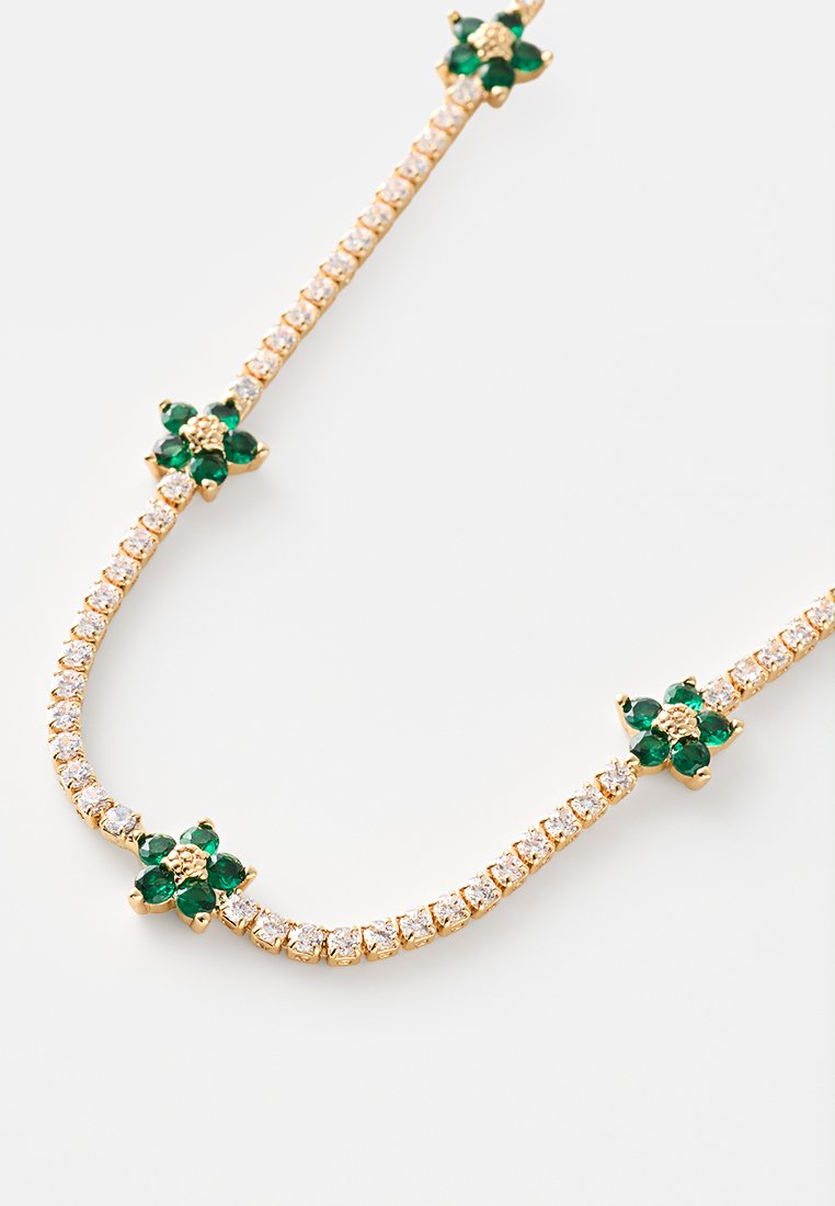 Collana in tonalità oro con grappoli di gemme verdi alternate a strass chiari, creando un delicato motivo floreale.
