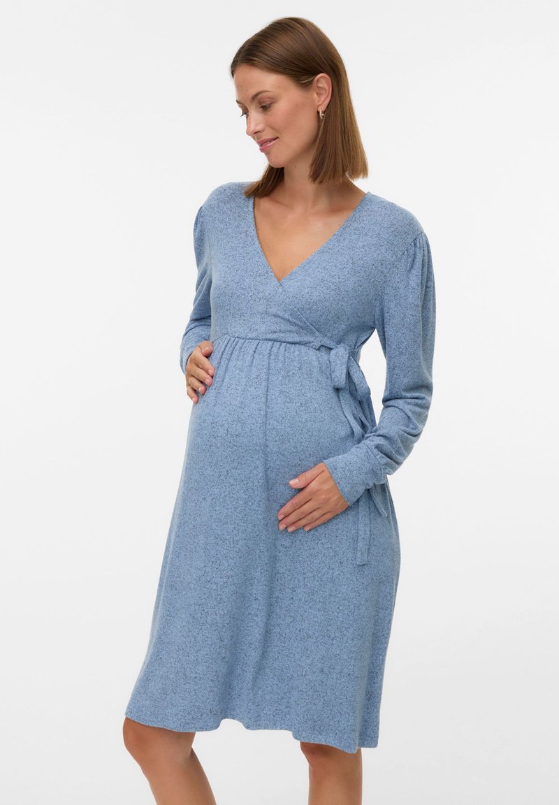 Jasnoniebieska sukienka ciążowa o fasonie kopertowym, wykonana z miękkiego materiału. Posiada długie rękawy, wiązanie w pasie oraz luźny krój.