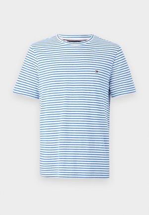 T-shirt blanc col rond avec fines rayures horizontales bleues et petit logo rectangulaire rouge et marine sur la poitrine.
