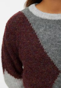 Sweter dzianinowy z wzorem w diamenty w kolorze bordowym i szarym, z jasnoszarym ściągaczem przy dekolcie. Teksturowany, miękki materiał z mieszanki wełny.