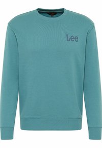 Sudadera verde azulado hecha de un tejido suave, con cuello redondo, mangas largas, puños y dobladillo acanalados, y un pequeño logotipo impreso en el pecho.