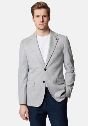 Szary żakiet wykonany z gładkiego materiału, z dwoma przednimi kieszeniami, czarnymi guzikami i zapięciem na jeden guzik. Nosi się go na białym t-shircie.