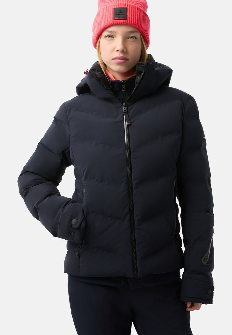 Marineblaue Pufferjacke mit Kapuze, ausgestattet mit einem Reißverschluss vorne, Druckknopfmanschetten und Seitentaschen. Glatte Textur mit gepolsterten Bereichen für Isolation.