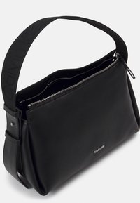 Borsa a spalla nera in pelle di Calvin Klein con tracolla in tessuto testurizzato, zip argentata e dettaglio con logo sul davanti. Design liscio e strutturato.