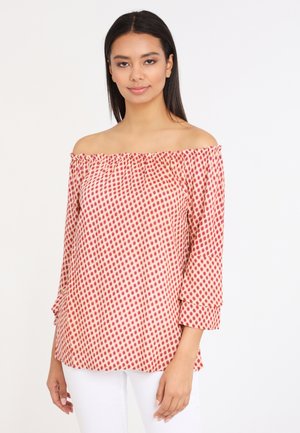Off-the-shoulder blouse in lightweight fabric, patterned with red dots on a beige background; features 3/4 bell sleeves and subtle gathering.