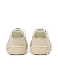 Kožené a semišové sneakers v béžové a zelené barvě s kulatými patami, texturovanými podrážkami a kontrastními akcenty. Minimalistický design bez šněrování.